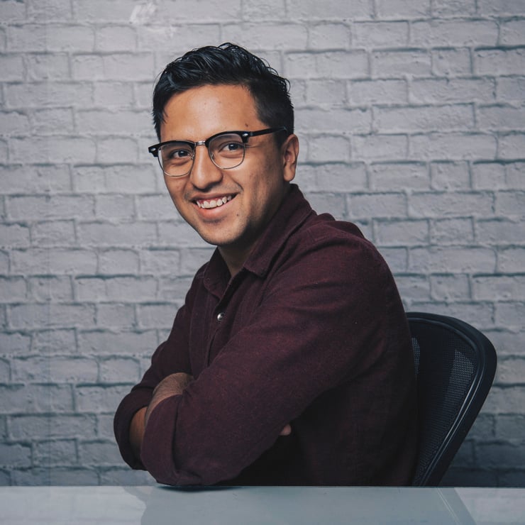 Cheerful Indian man sitting with crossed arms